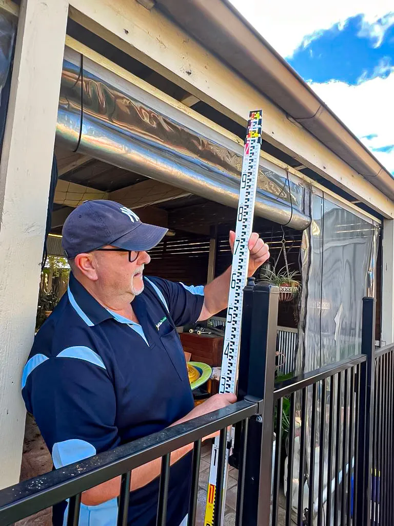 VBA-registered inspector in Hume measuring vertical fence height for compliance